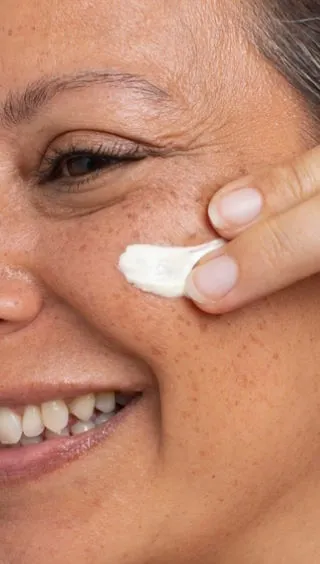 Mujer aplicando Glowy Care en el contorno de los ojos con la punta de los dedos