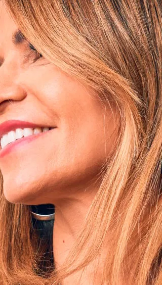 Mujer de más de 45 años con la piel luminosa y tono parejo tras su rutina de cuidado facial